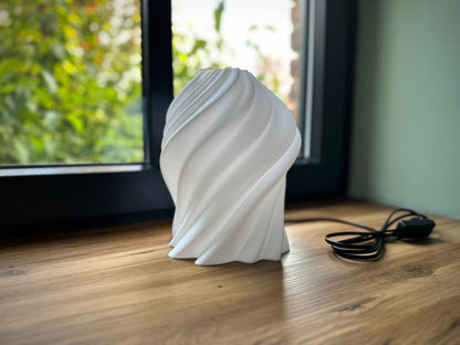 Weiße Designlampe aus 3D-Druck mit organischer Wellenstruktur, moderne LED-Leuchte als stilvolles Wohnaccessoire auf Fensterbank