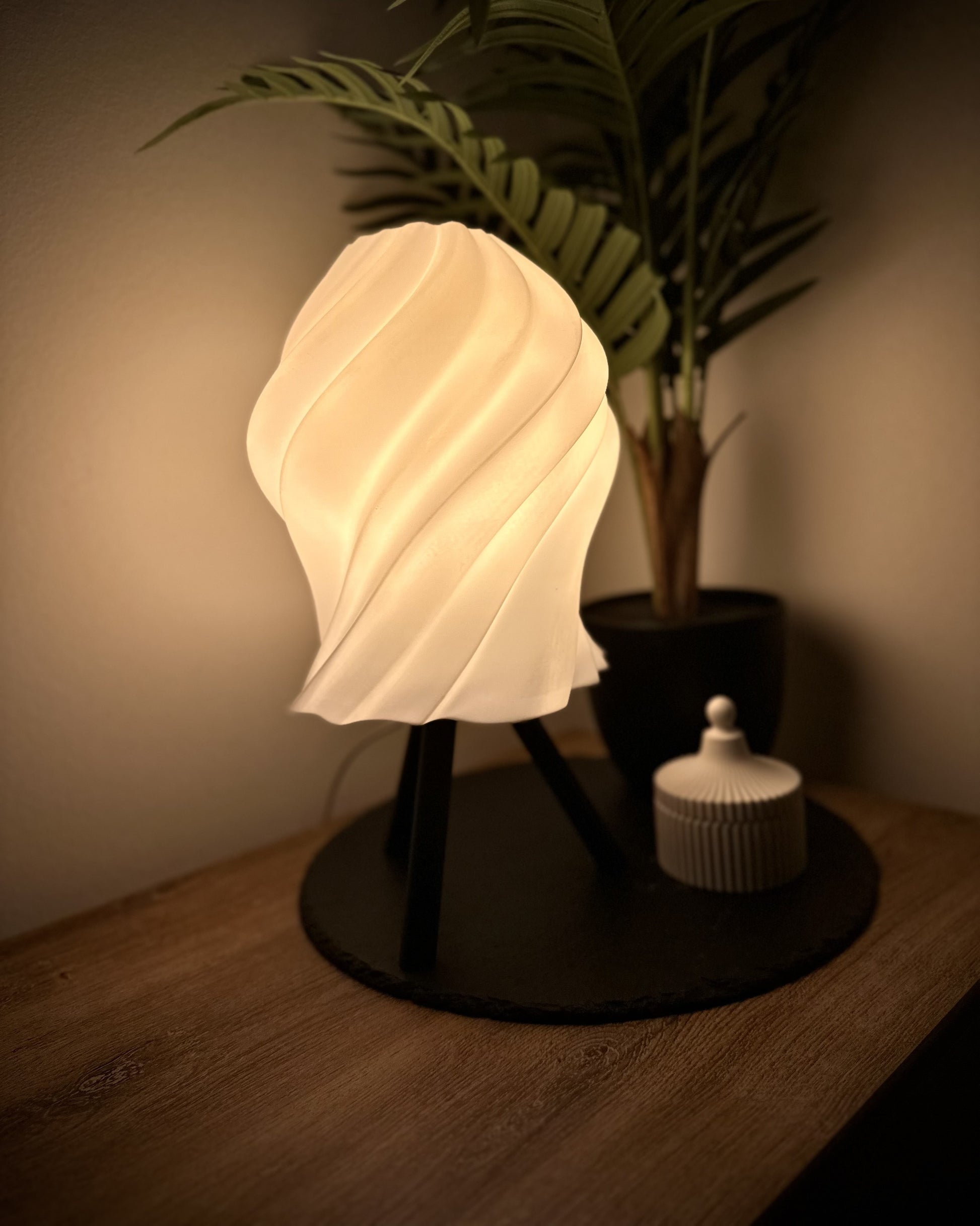 Minimalistische Tischlampe mit dimmbarem, geschwungenem Schirm und Dekodose als stilvolles Ensemble