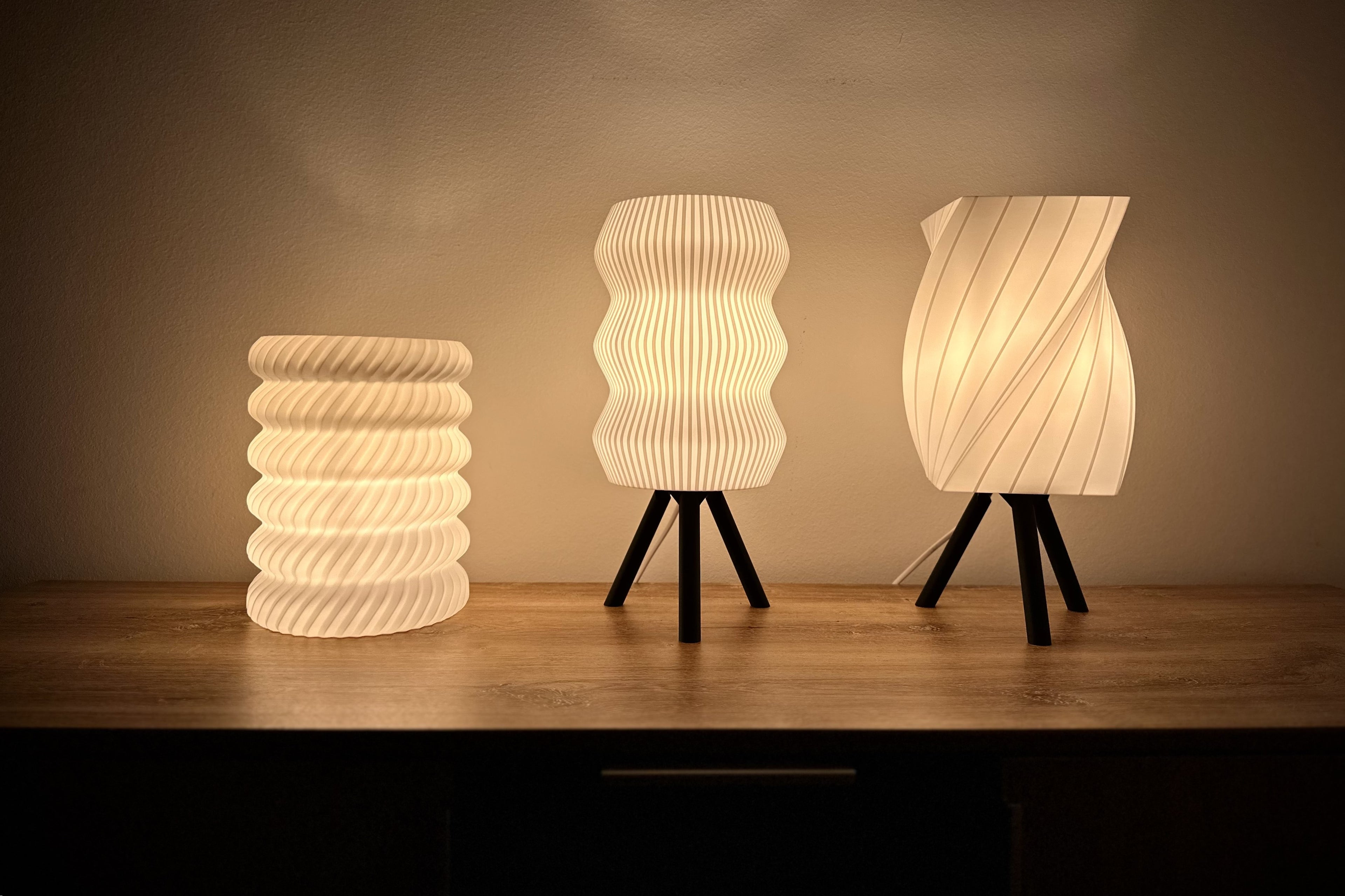 Moderne 3D-gedruckte Tischlampen im skandinavischen Design, warm beleuchtet auf einem Holztisch